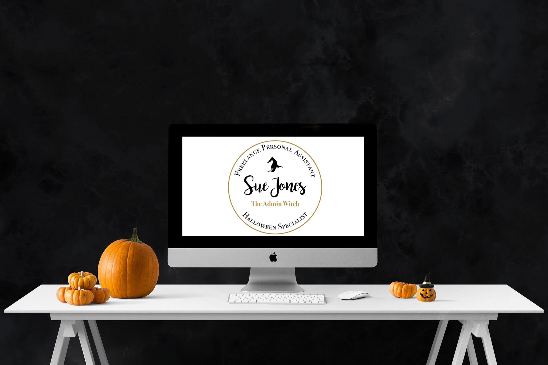 iMac on desk with pumpkins. Sue Jones, The Admin Witch Logo.